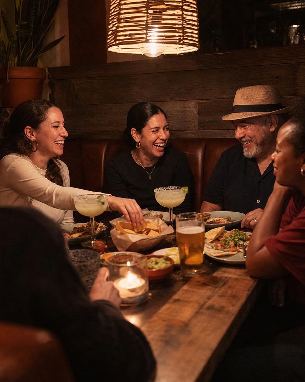 Friends laughing over cocktails at La Hacienda